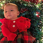 Phoebe is registered to the contest to win money with this photo: baby, infant, red_clothing, plaid_skirt, tinsel, holiday_lights, festive, christmas, sparkle, cute, face, portrait, child, young, indoors, celebration, colorful, decorations, smile, person