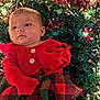 baby, infant, red_clothing, plaid_skirt, tinsel, holiday_lights, festive, christmas, sparkle, cute, face, portrait, child, young, indoors, celebration, colorful, decorations, smile, person