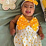 baby, infant, child, polka_dot, bow, headband, milestone, 4_months, smiling, tongue_out, cute, lying_down, blanket, flower_sign, orange, white, happy, celebration, portrait, playful