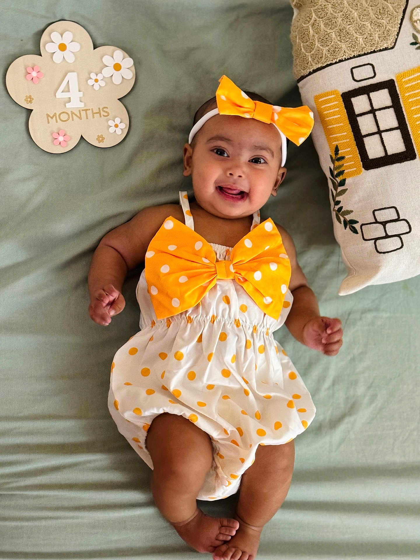 Zaifa is registered to the contest to win money with this photo: baby, infant, child, smiling, polka_dot, bow, headband, dress, lying_down, blanket, pillow, decor, flower_sign, months, happy, cute, indoors, skin, foot, hand