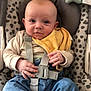 baby, infant, child, seat, baby_seat, straps, clothing, denim_pants, yellow_cloth, hand, face, eyes, ears, dog_legs, patterned_fabric, indoor, comfort, cute, sitting, portrait