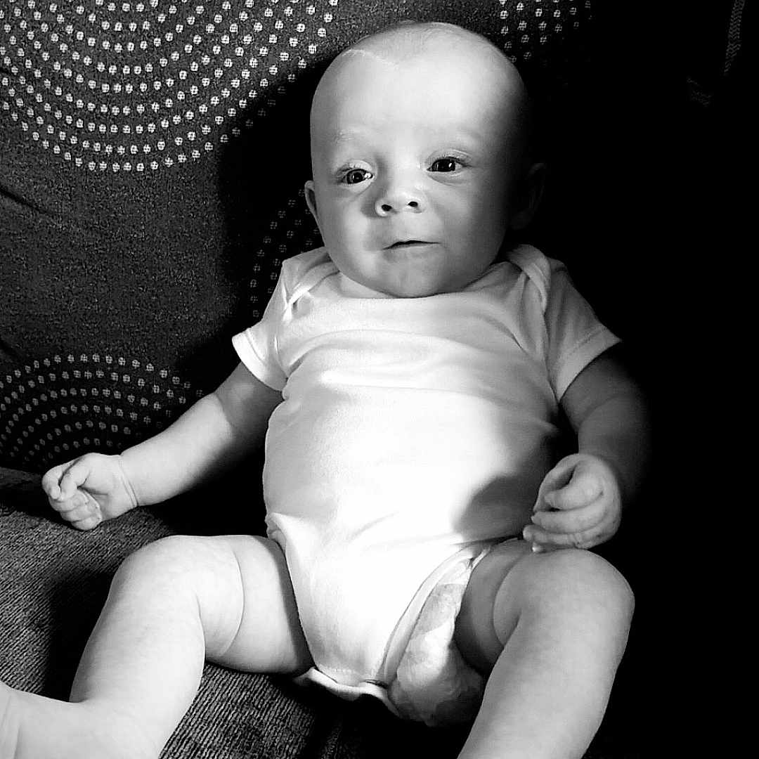 Lincon joined the competition — help win amazing prizes! arms, baby, child, comfortable, couch, curious, expression, face, feet, home, indoor, infant, legs, monochrome, onesie, patterned_cushion, portrait, relaxed, sitting, soft_light