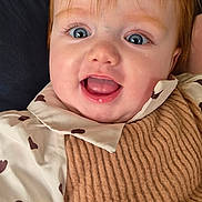 Oxana a rejoint le concours — aidez-le/la à gagner de superbes lots ! baby, child, smiling, happy, face, blue_eyes, red_hair, knitted_bib, heart_pattern, clothing, portrait, close_up, cute, infant, person, apparel, warm, indoor, adult_arm, joyful