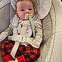 baby, infant, pacifier, red_pants, plaid_pants, white_gloves, baby_seat, seatbelt, cute, holiday_outfit, santa_claus, cozy, cushion, soft, child, clothing, indoors, portrait, comfortable, young
