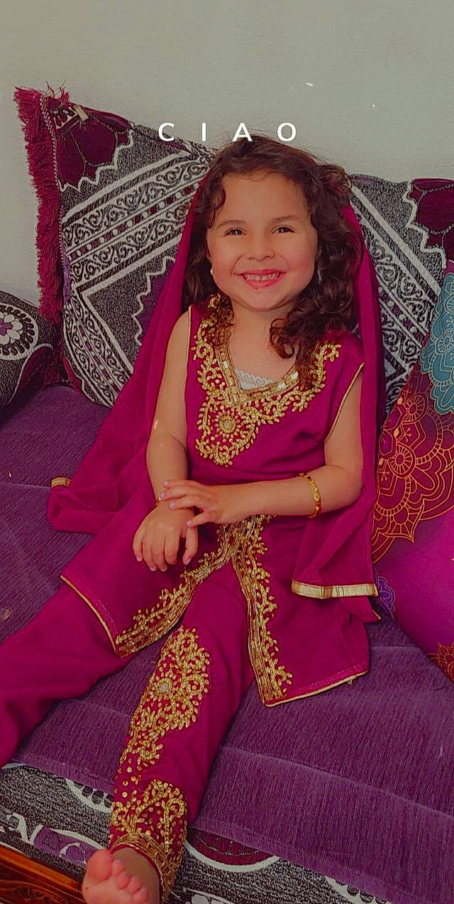 Nayla participe au concours pour gagner de l'argent avec cette photo : arm, event, face, fashion_design, formal_wear, happy, head, human_body, human_leg, jewellery, joy, long_hair, magenta, pattern, peach, person, pink, purple, skin, sleeve