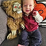 baby, child, toy, monster_doll, couch, pillow, striped_pillow, red_eyes, claws, fur, happy, smile, jeans, sweater, bare_feet, indoor, portrait, cute, plush_toy, seated