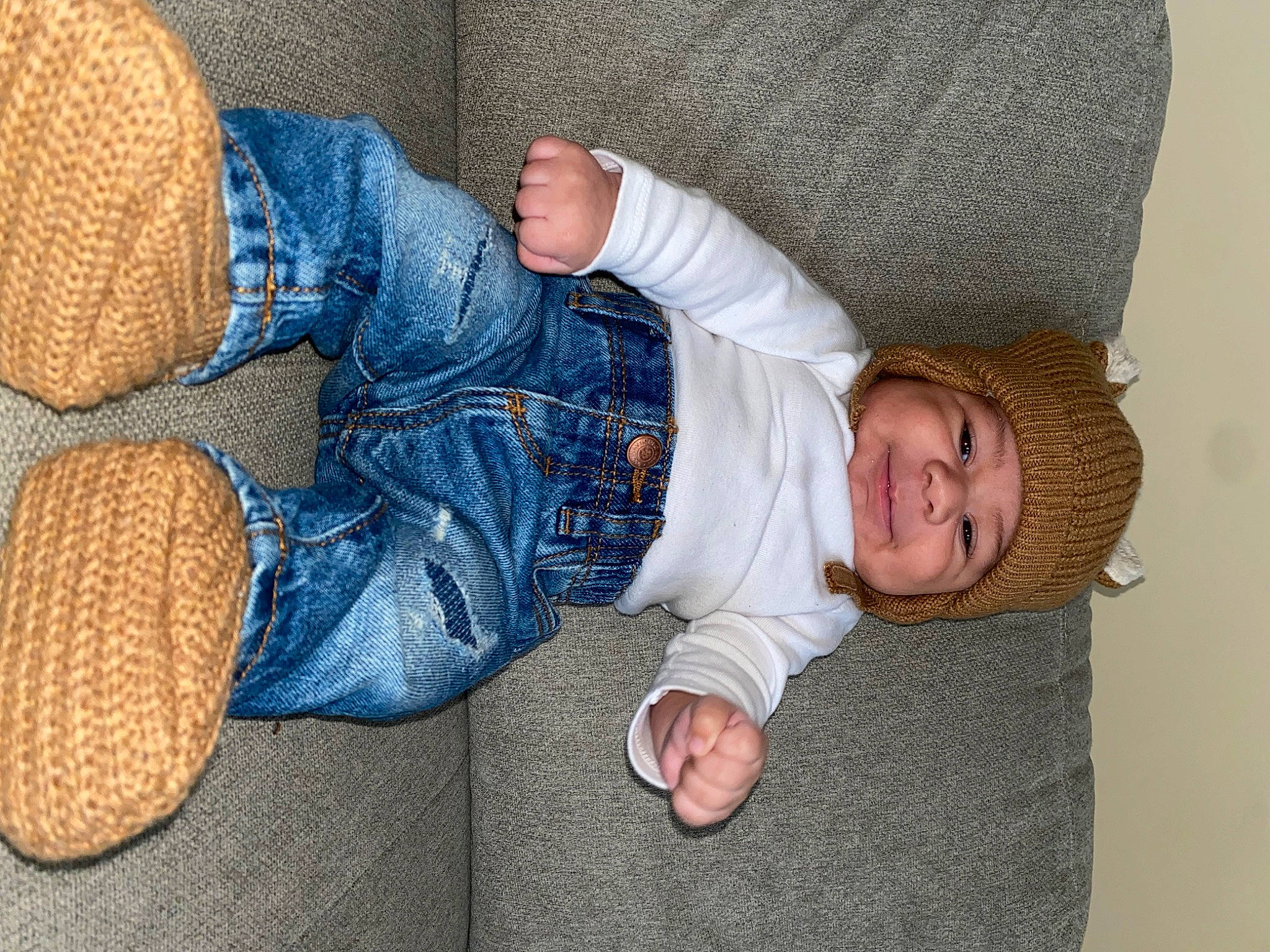 Nico is registered to the contest to win money with this photo: baby, baby_toddler_clothing, child, comfort, denim, electric_blue, finger, foot, gesture, hand, headwear, leg, linens, mammal, pattern, person, sitting, skin, sleeve, thumb