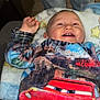 baby, smiling, fleece, blanket, lightning_mcqueen, child, happy, indoor, person, clothing, jeans, cozy, cute, infant, portrait, red, blue, toy_story, raised_hand, relaxed