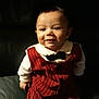 Tiago a rejoint le concours — aidez-le/la à gagner de superbes lots ! baby, child, smiling, suit, bow_tie, red_clothing, pinstripe, infant, portrait, indoors, leather_couch, cute, happy, person, young, seated, fashion, formal_wear, small_hands, dark_background