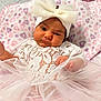 Daphne is registered to the contest to win money with this photo: baby, infant, child, white_bow, headband, lace_outfit, tulle_skirt, pink_blanket, purple_hearts, soft_texture, cute, portrait, indoors, hand, face, expression, fashion, clothing, newborn, lying_down