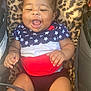 baby, child, smiling, laughing, infant, star_pattern, red_white_blue, leopard_print, cushion, seat, cute, happy, portrait, clothing, skin, hand, legs, indoor, young, person