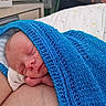 arm, baby, bedroom, blue_blanket, closeup, comfort, cozy, indoor, infant, knitted_blanket, newborn, peaceful, person, pillow, portrait, resting, skin, sleeping, soft_lighting, tiny