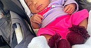 Athena joined the competition — help win amazing prizes! baby, newborn, sleeping, car_seat, blanket, headband, flower, pink_clothing, purple_clothing, infant, child, cute, cozy, soft, resting, hands, feet, accessory, car_interior, portrait
