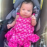 Athena is registered to the contest to win money with this photo: baby, child, car_seat, pink_dress, blanket, indoor, infant, clothing, seatbelt, cute, portrait, person, young_child, safety_warning, car_interior, baby_girl, comfortable, expression, seated, hair