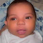 Matthias is registered to the contest to win money with this photo: baby, blanket, blue_blanket, child, closeup, curly_hair, cute, expression, eyes, face, indoors, infant, mohawk, mouth, newborn, person, portrait, soft_skin, white_clothing, young_child