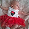 baby, baby_girl, blue_eyes, child, clothing, curious, cute, fabric, indoors, infant, lying_down, minnie_mouse, portrait, red_skirt, socks, soft_blanket, soft_lighting, texture, tutu_skirt, white_top