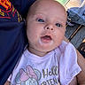 baby, infant, face, blue_eyes, milk, mouth, clothing, minnie_mouse, shirt, person, hand, holding, coca_cola, bottle, backpack, outdoor, wood, casual, close_up, cute