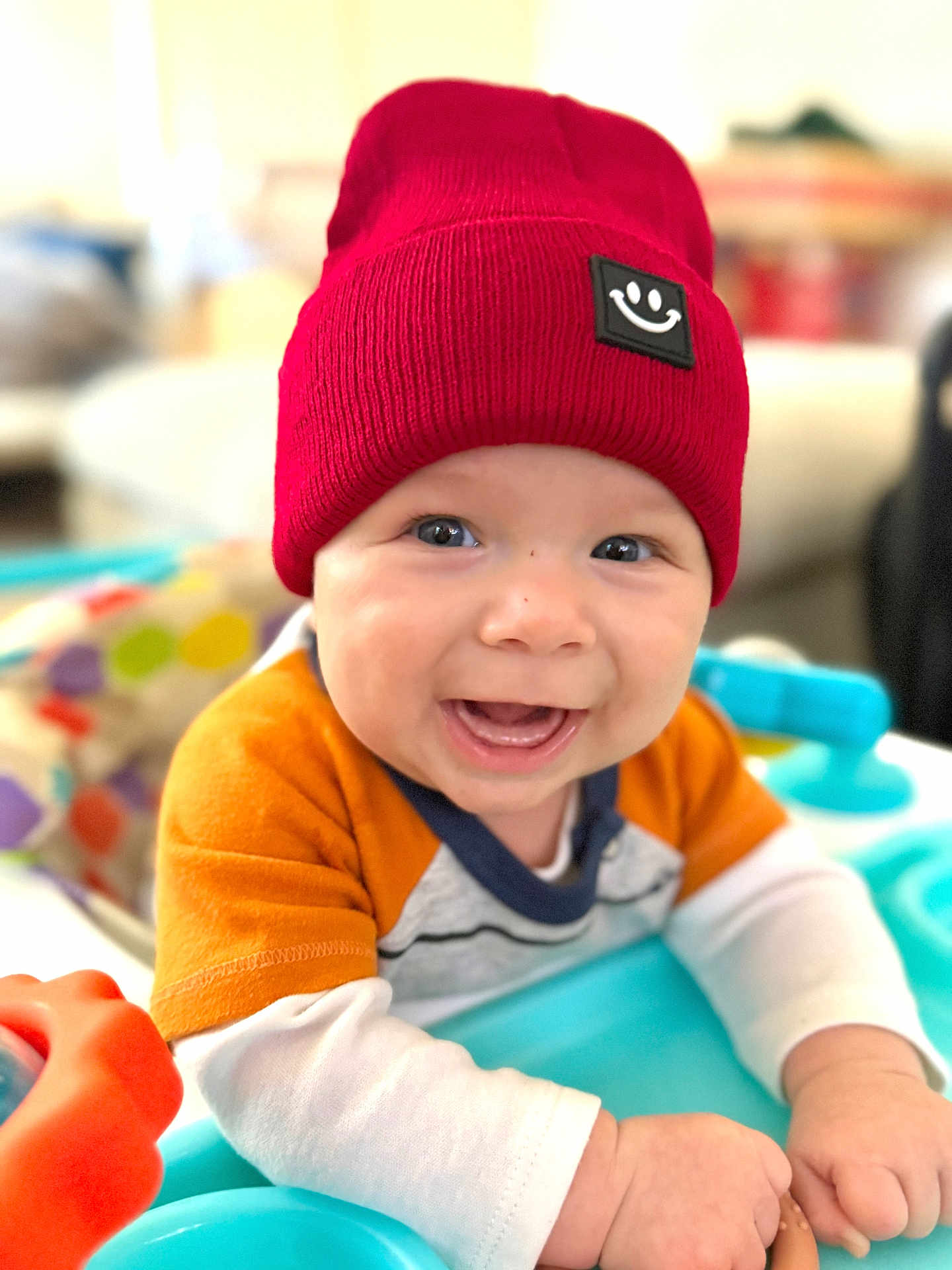 Trent joined the competition — help win amazing prizes! baby, child, smiling, red_hat, knit_hat, toy, indoor, happy, face, cute, infant, clothing, colorful, playtime, hands, portrait, closeup, expression, sitting, bright