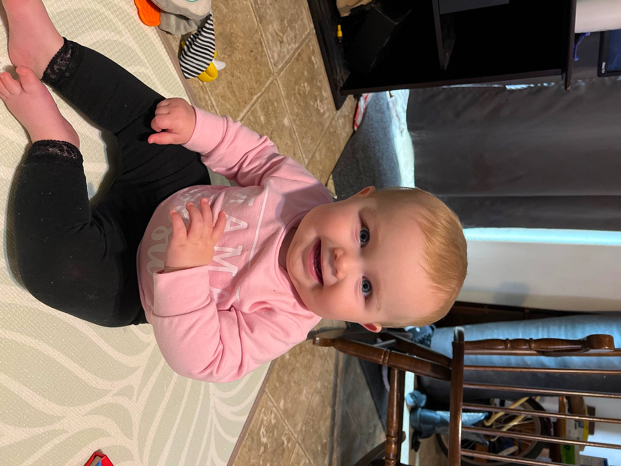 Rowen is registered to the contest to win money with this photo: baby, baby_products, baby_toddler_clothing, child, foot, fun, gesture, hand, human_leg, joy, knee, mouth, nail, person, sitting, smile, thigh, thumb, toddler, wood