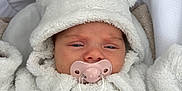 Léna participe au concours pour gagner de l'argent avec cette photo : baby, babywear, child, childhood, comfort, cushion, cute, face, headwear, hoodie, indoors, infant, newborn, pacifier, portrait, sleepy, soft_texture, stroller, warm_clothing, white_clothing
