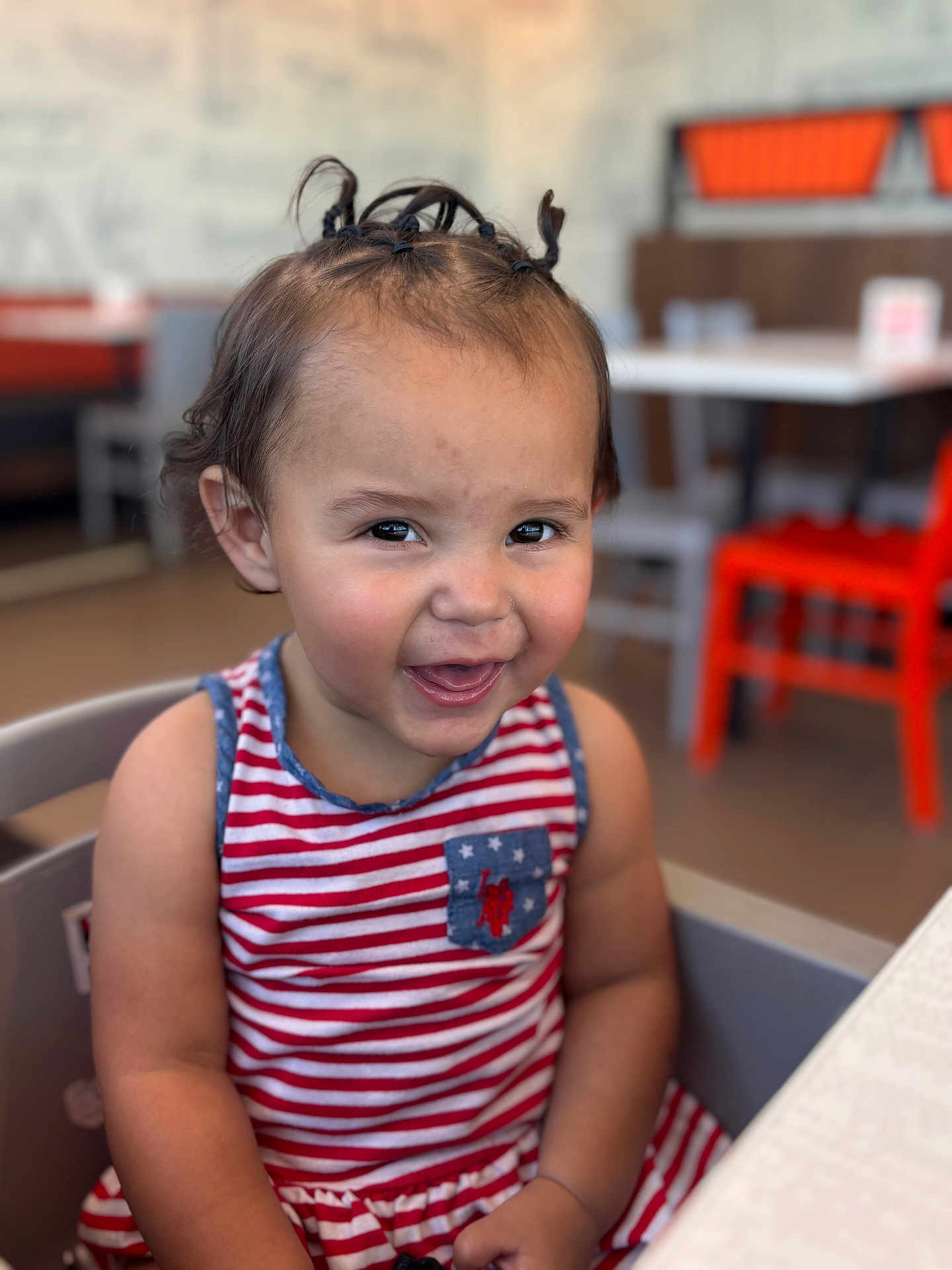 Zareya joined the competition — help win amazing prizes! toddler, child, smiling, happy, striped_dress, pigtails, high_chair, indoor, restaurant, table, chair, person, cute, portrait, casual, seated, hair, face, baby, fun