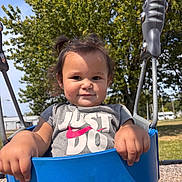 Zareya is registered to the contest to win money with this photo: toddler, child, swing, playground, outdoor, smiling, happy, person, shirt, clothing, grass, tree, sky, daylight, nature, fun, play, cute, park, metal