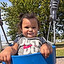 toddler, child, swing, playground, outdoor, smiling, happy, person, shirt, clothing, grass, tree, sky, daylight, nature, fun, play, cute, park, metal