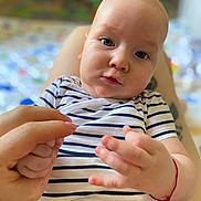 Vladimir a rejoint le concours — aidez-le/la à gagner de superbes lots ! adult_hand, baby, blue_eyes, blurred_background, casual_clothing, child, close_up, cute, expression, fingers, hand, indoor, infant, intimate_moment, person, portrait, skin, soft_light, striped_shirt, young