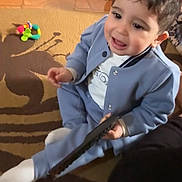 Malek El Euch participe au concours pour gagner de l'argent avec cette photo : blue_clothing, carpet, child, colorful, couch, cozy, cute, face, floor, hair, happy, home, indoor, pattern, playful, remote_control, sitting, smiling, toddler, toy