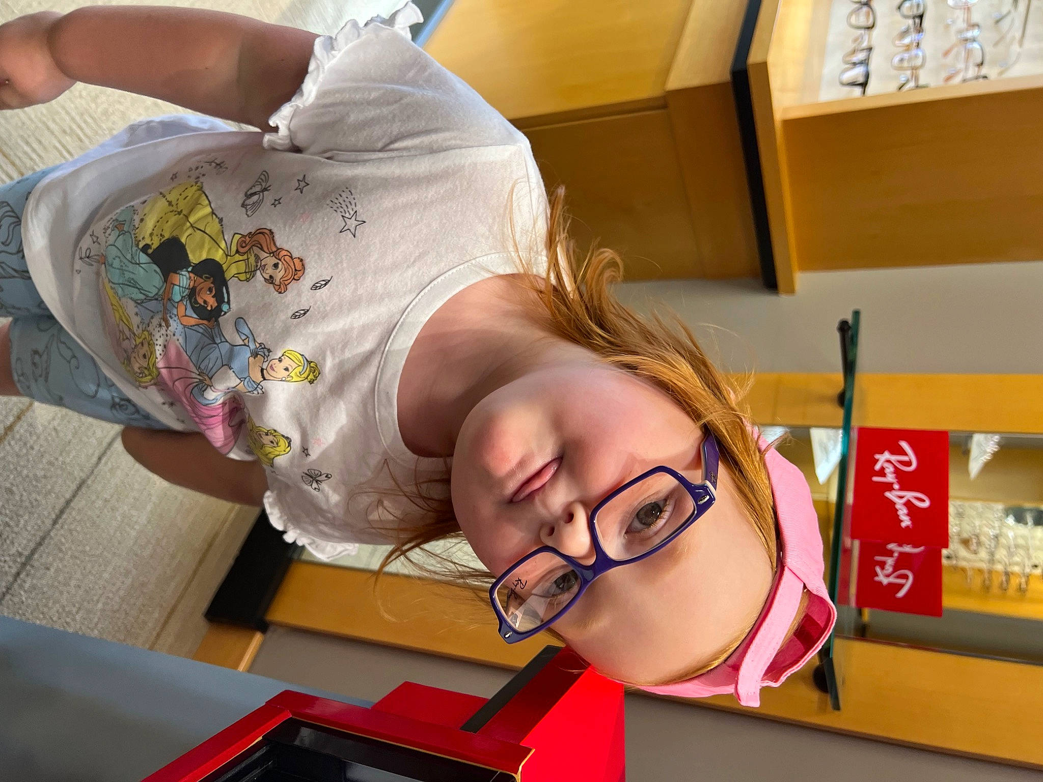 Maci is registered to the contest to win money with this photo: carton, child, comfort, eyelash, eyewear, fun, glasses, headwear, homework, learning, person, room, shipping_box, toddler, vision_care, writing