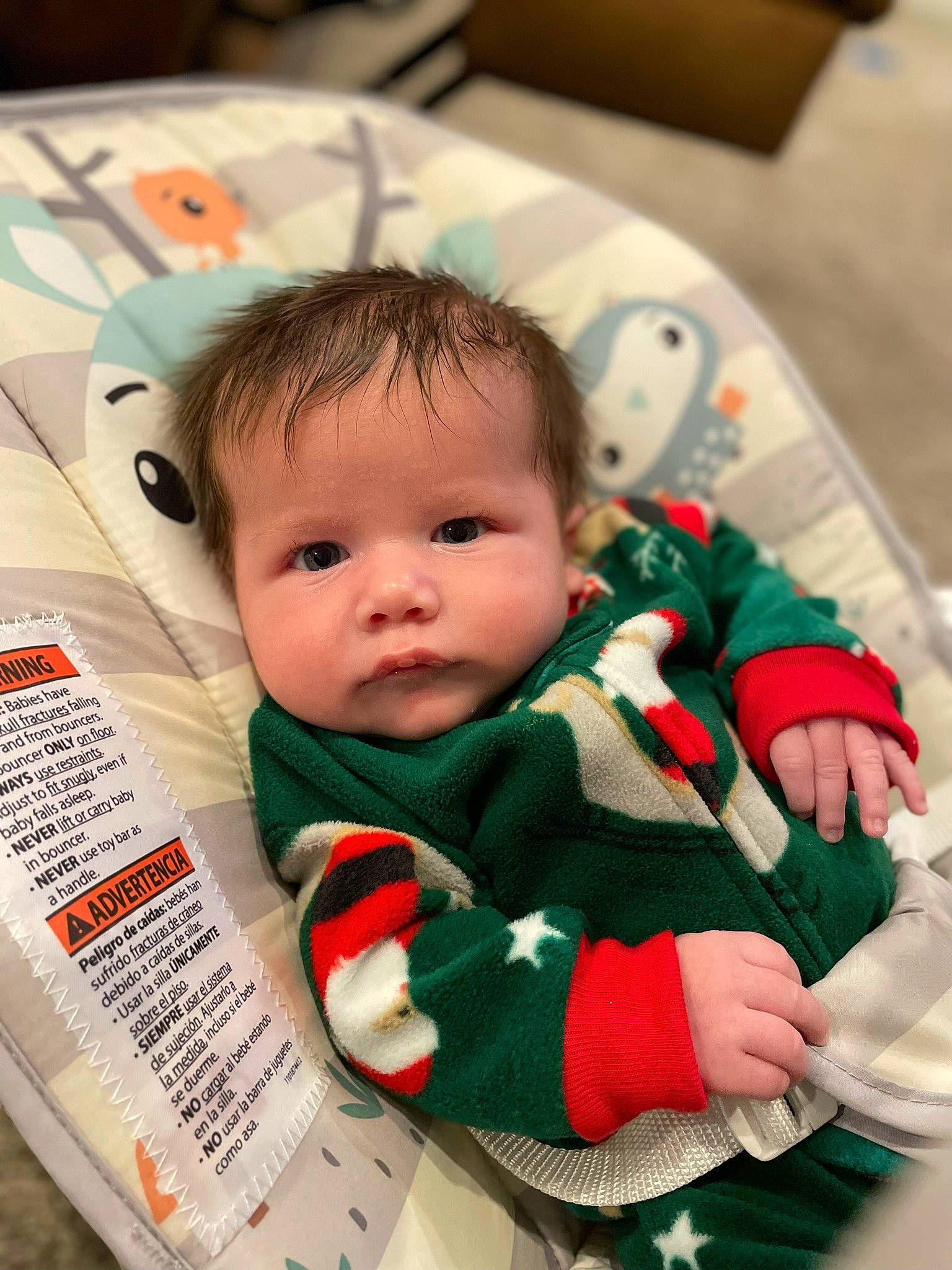 Dylan is registered to the contest to win money with this photo: baby, baby_products, baby_toddler_clothing, carmine, cheek, child, christmas, event, eye, face, happy, head, holiday, linens, pattern, person, room, sitting, skin, toddler