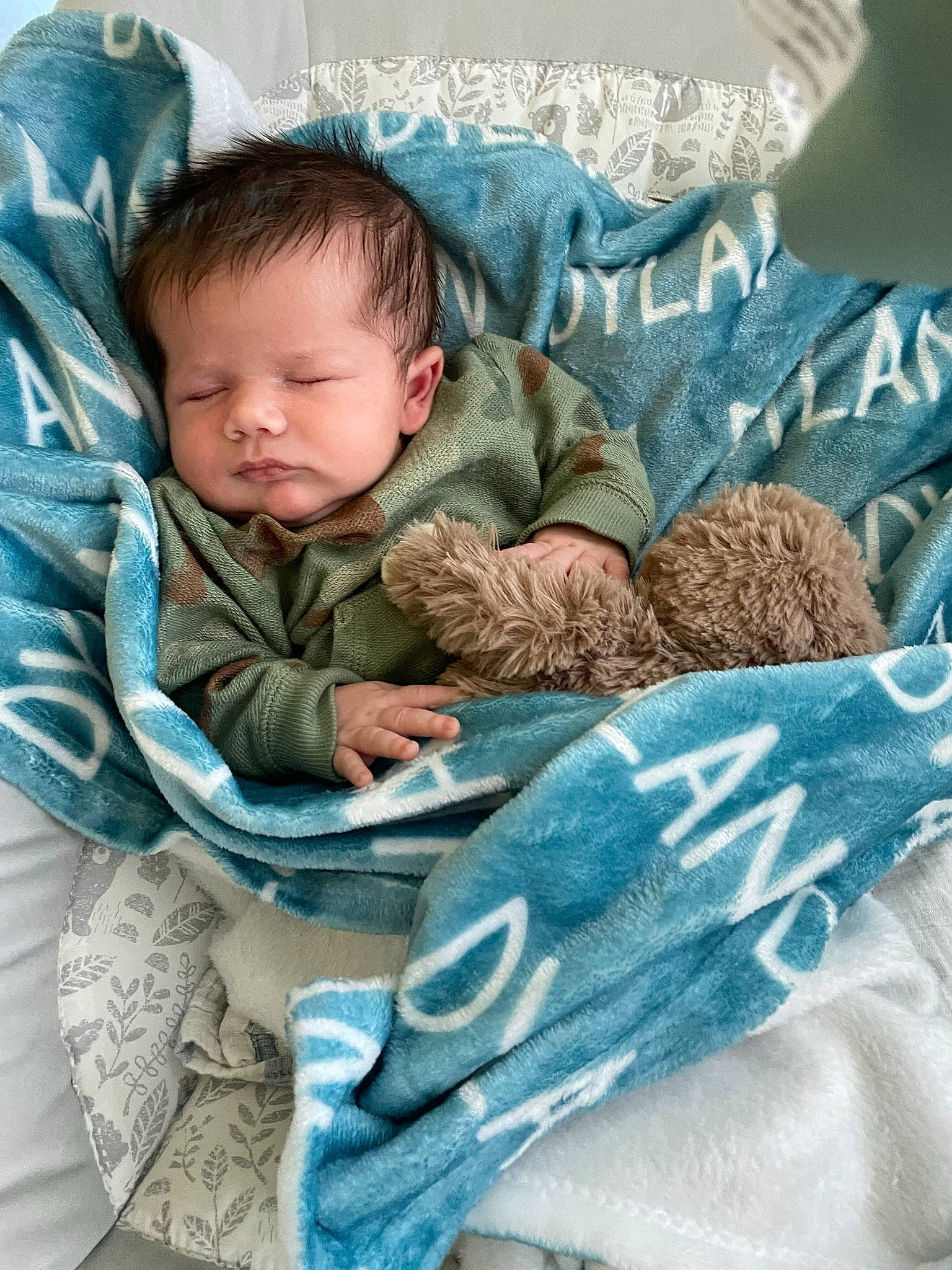 Dylan is registered to the contest to win money with this photo: baby, baby_products, baby_sleeping, baby_toddler_clothing, child, comfort, couch, eye, face, grass, grey, head, linens, mammal, outerwear, person, product, sitting, textile, toddler