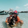 man, woman, dog, water, beach, sunny, hat, sunglasses, boat, jet_ski, can, bird, sky, outdoor, summer, vacation, happy, smile, shallow_water, nature