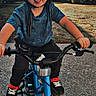 Chase is registered to the contest to win money with this photo: child, helmet, glasses, bike, bicycle, outdoor, sidewalk, playful, tongue_out, blue_bike, casual_clothing, sneakers, trees, house, sunlight, daytime, person, smiling, young_child, recreation