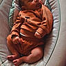 Kamari is registered to the contest to win money with this photo: baby, sleeping, infant, baby_rocker, orange_clothing, cozy, cute, child, padded, comfort, resting, indoor, soft_lighting, peaceful, young_child, newborn, face, legs, hands, fabric