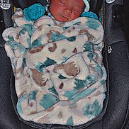 Kamari is registered to the contest to win money with this photo: newborn, baby, infant, car_seat, blanket, hat, sleeping, child, cozy, cute, resting, indoors, footwear, foot, black, fabric, pattern, soft, warm, toddler