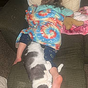 Karma is registered to the contest to win money with this photo: child, cat, blanket, chair, cushion, carpet, foot, sleeping, resting, indoor, furniture, cozy, home, nap, pet, animal, toddler, colorful, tie_dye, relaxation