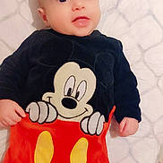 Adam a rejoint le concours — aidez-le/la à gagner de superbes lots ! baby, infant, mickey_mouse, clothing, red_pants, black_shirt, cartoon_character, cute, smile, lying_down, blanket, soft_texture, child, portrait, indoors, face, eyes, hand, fingers, young