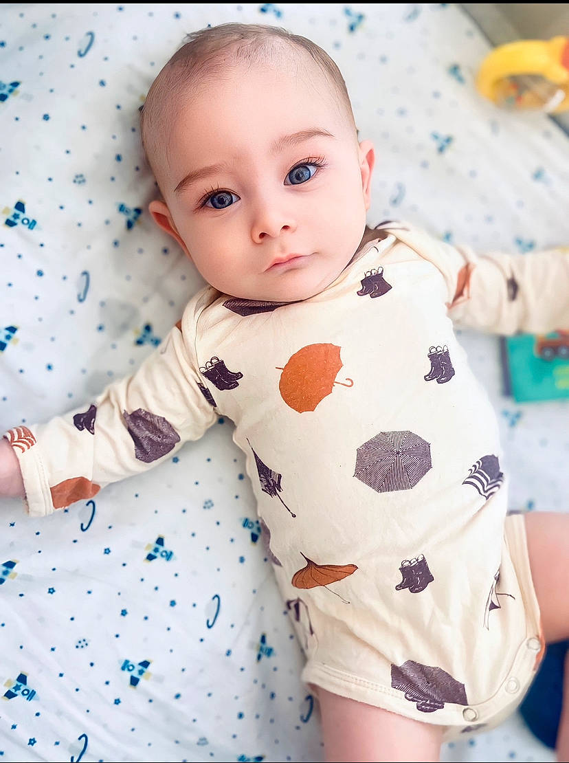 Colton is registered to the contest to win money with this photo: baby, baby_products, baby_toddler_clothing, cheek, child, electric_blue, fun, happy, linens, pattern, person, pink, portrait_photography, product, sitting, skin, sleeve, standing, t_shirt, textile