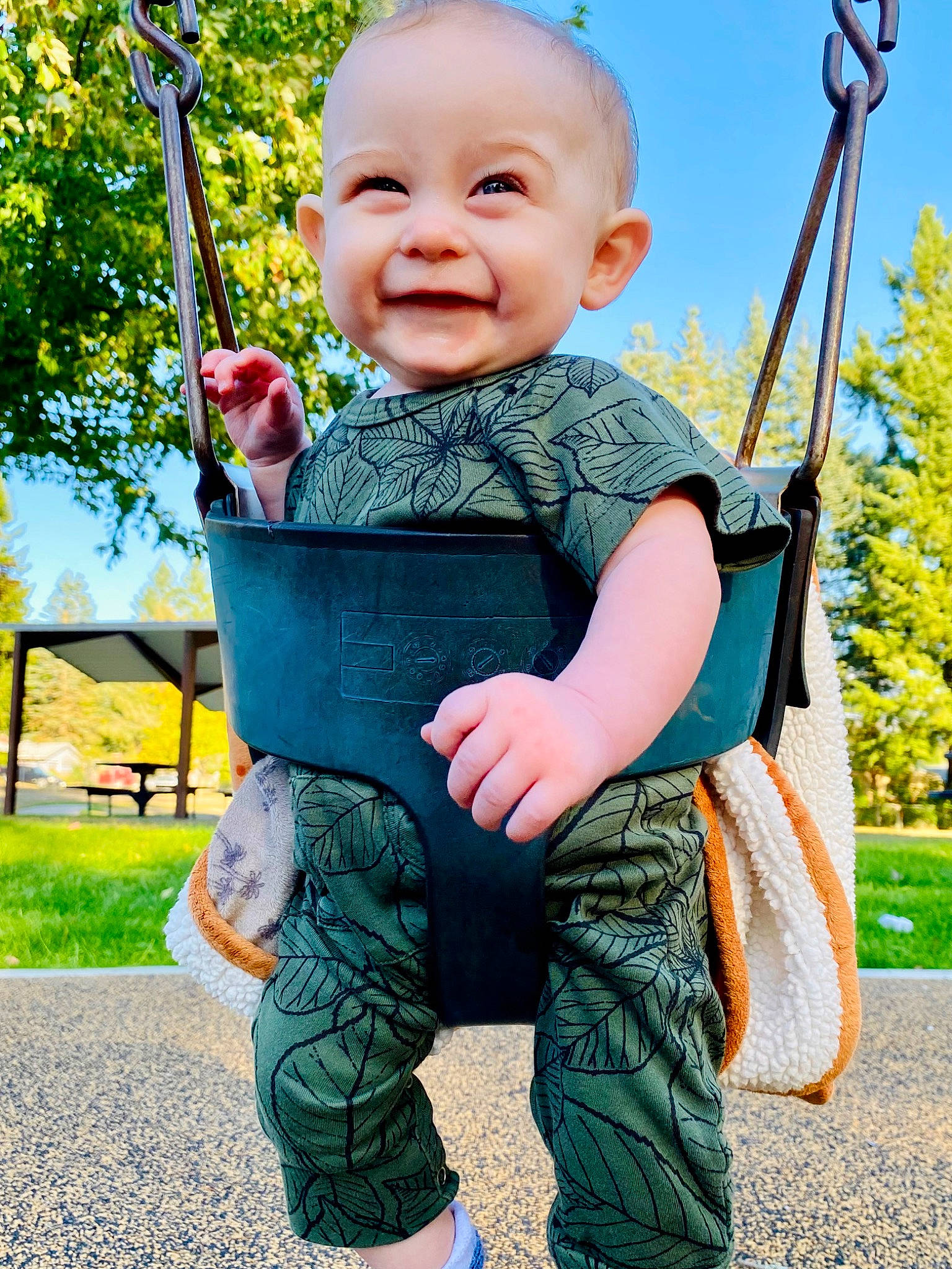 Colton is registered to the contest to win money with this photo: baby, baby_toddler_clothing, fun, gesture, grass, happy, joy, leisure, people_in_nature, person, plant, playground, recreation, skin, sky, sleeve, smile, standing, summer, swing