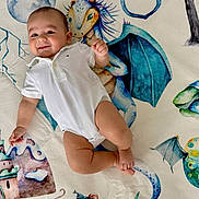 Camilo is registered to the contest to win money with this photo: baby, blanket, castle, child, colorful, cute, dragon, fantasy, happy, illustration, indoor, infant, lying_down, moon, mouse, playful, portrait, smile, tree, white_onesie