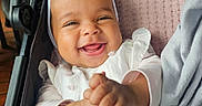 Emilia is registered to the contest to win money with this photo: baby, baby_girl, blanket, child, clapping, closeup, comfortable, cute, flower, hands, happy, headband, indoors, infant, portrait, seat, smiling, soft_light, stroller, white_clothing