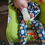 Kaladin is registered to the contest to win money with this photo: baby, sleeping, bottle, pajamas, child, infant, seat, cushion, pattern, milk, cookie, clothing, indoor, carpet, toy, hand, face, head, comfort, nap