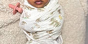 Myaria is registered to the contest to win money with this photo: baby, blanket, bow, child, clothing, comfort, cozy, cute, face, head, indoor, infant, newborn, pacifier, person, portrait, resting, sleepy, soft, swaddle