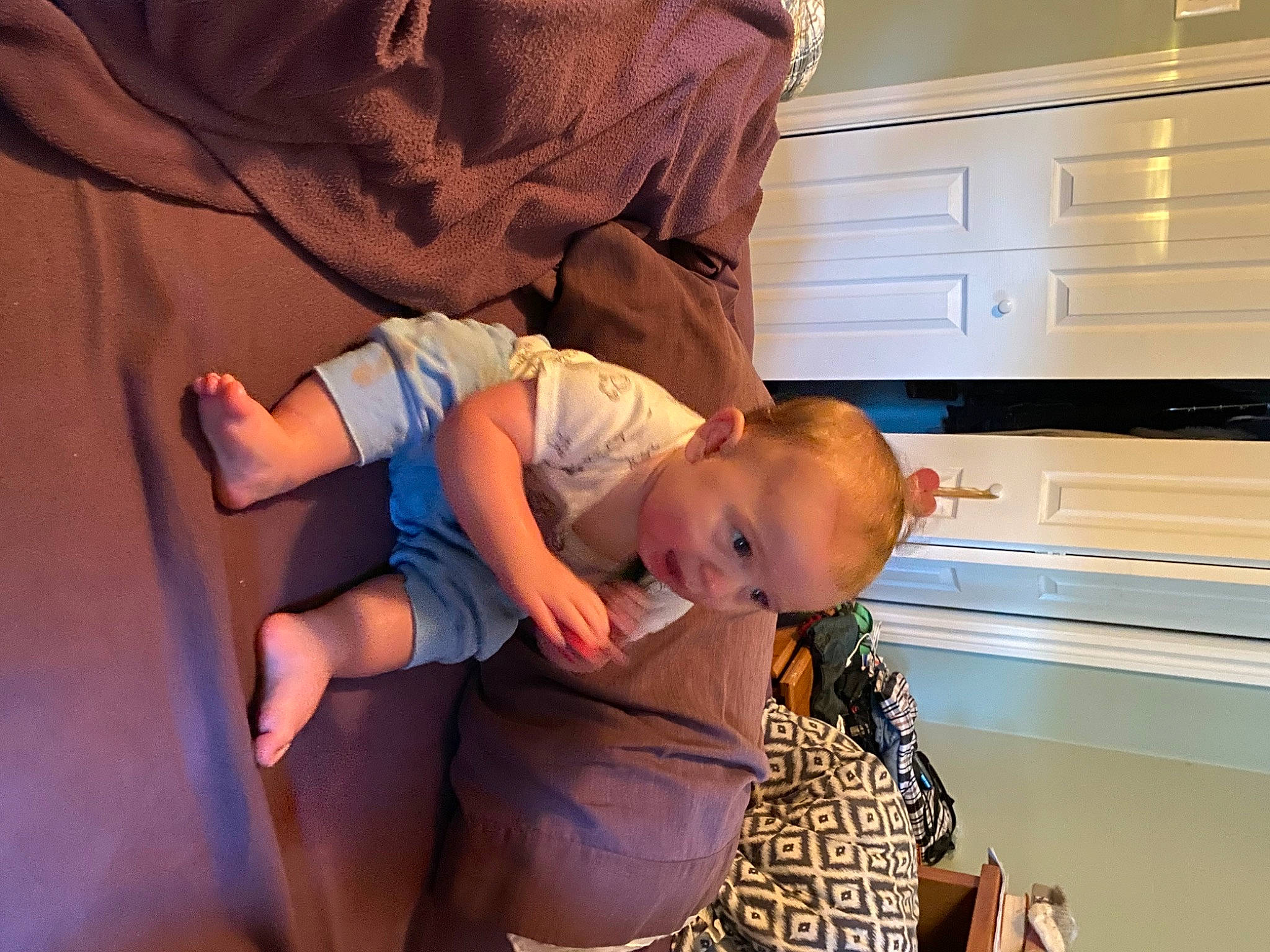 Benson is registered to the contest to win money with this photo: abdomen, baby, baby_toddler_clothing, cabinetry, child, comfort, elbow, fun, gesture, happy, human_leg, kitchen, knee, person, sitting, t_shirt, thigh, thumb, toddler, trunk
