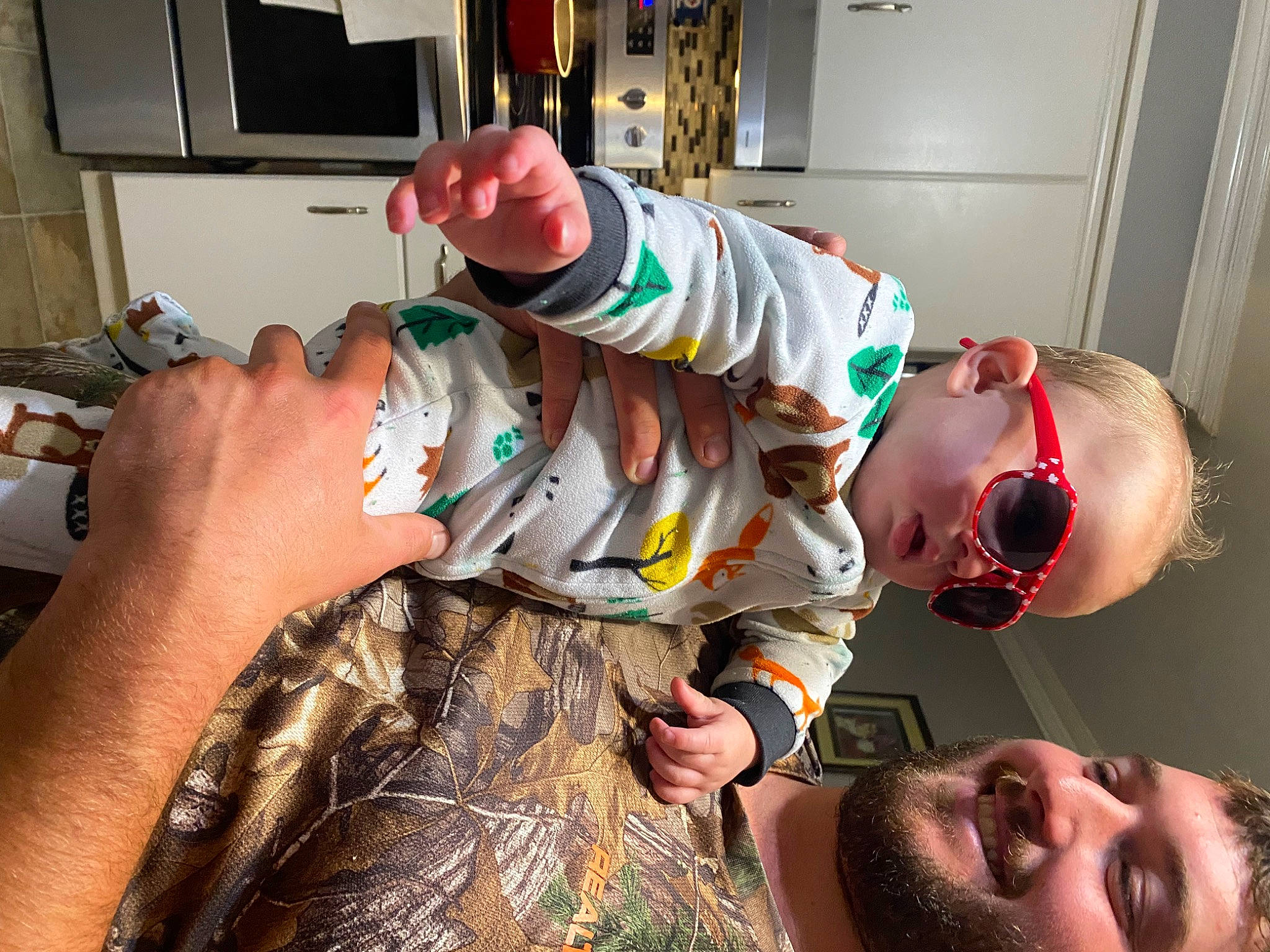 Benson is registered to the contest to win money with this photo: arm, baby, beard, child, eyewear, finger, fun, gesture, goggles, happy, joy, kitchen_appliance, military_camouflage, mouth, muscle, organ, pattern, person, room, sunglasses
