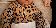 Lara is registered to the contest to win money with this photo: baby, sleeping, infant, blanket, leopard_print, onesie, face, child, cushion, soft_toy, cozy, resting, portrait, closeup, indoor, peaceful, cute, warm, comfort, sleep
