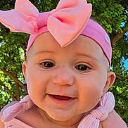 Amelia is registered to the contest to win money with this photo: baby, blue_sky, child, closeup, clothing, cute, green_leaves, happy, headband, holding_hands, infant, nature, outdoor, person, pink_bow, portrait, smile, summer, sunlight, tree