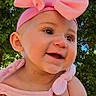 Amelia is registered to the contest to win money with this photo: baby, baby_girl, blue_sky, child, clothing, cute, daylight, greenery, hands, happy, headband, infant, nature, outdoor, person, pink_bow, portrait, smiling, sunlight, tree