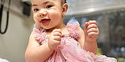 Allison joined the competition — help win amazing prizes! baby, child, girl, pink_dress, flower_headband, smiling, portrait, cute, indoors, soft_lighting, happy, infant, adorable, hands_up, closeup, window, blurred_background, skin, headband, floral